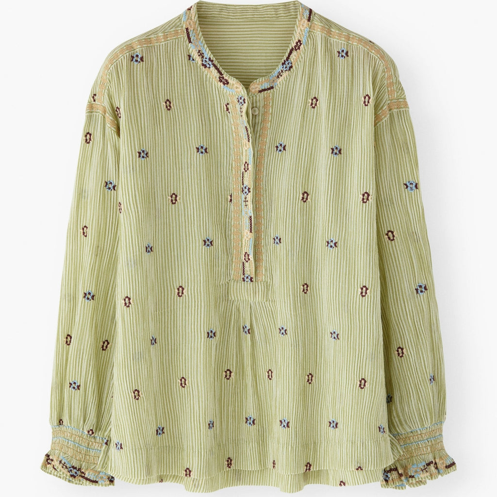 Green patterned blouse on a white background