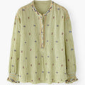 Green patterned blouse on a white background